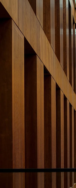 Interior of a Berlin building with a long corridor of warm wooden columns and ceiling panels, creating a structured pattern. Interior of a Berlin building with a long corridor of warm wooden columns and ceiling panels, creating a structured pattern.